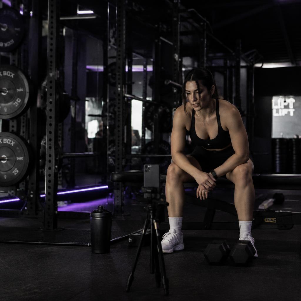 A fitness creator filming a workout in the gym